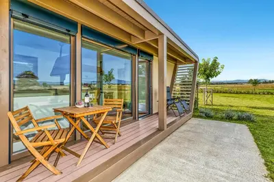 a wooden deck with a table and chairs on it at Riverside Suite Mobile Homes in Gradac