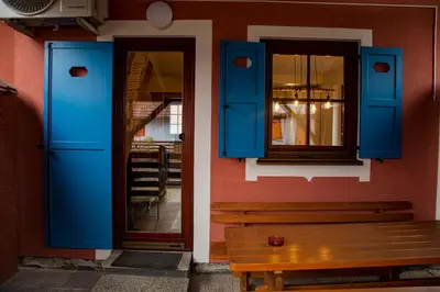 a building with blue doors and a wooden bench at DEMI108 - Terme čatež - pool tickets included in Čatež ob Savi