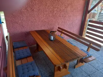a wooden bench and two blue chairs next to a wall at DEMI108 - Terme čatež - pool tickets included in Čatež ob Savi