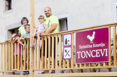 a group of people sitting on a fence at Toncevi Eco Estate in Branik