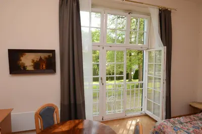 a living room with a large window and a table at Apartments Vektor Vila Golf in Rogaška Slatina