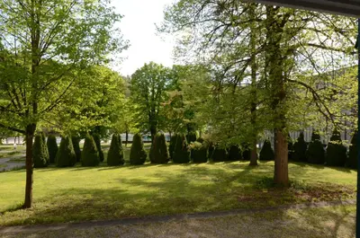 a park with trees and grass and a building at Apartments Vektor Vila Golf in Rogaška Slatina