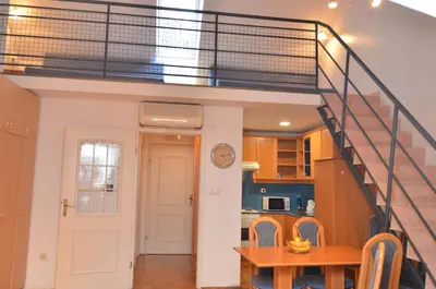 a room with a staircase and a kitchen with a table at Apartments Vektor Vila Golf in Rogaška Slatina