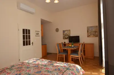 a bedroom with a bed and a table with chairs at Apartments Vektor Vila Golf in Rogaška Slatina