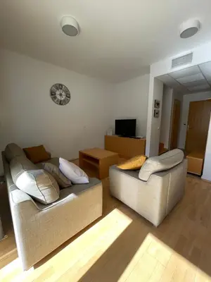 a living room with two couches and a television at JZ Apartments - Pohorje in Maribor