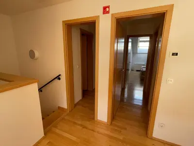 a hallway with two doors and a room with wood floors at JZ Apartments - Pohorje in Maribor