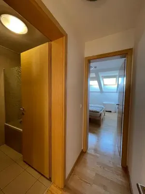 a hallway with a door to a room with a bed at JZ Apartments - Pohorje in Maribor