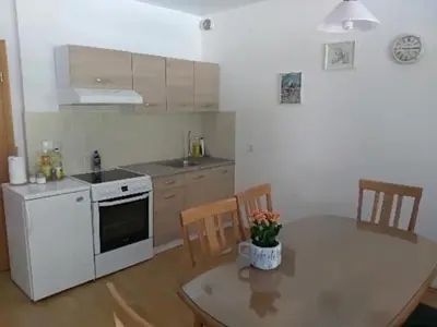 a kitchen with a table and a white stove top oven at Apartmaji Boštjan Pristavec in Kranjska Gora