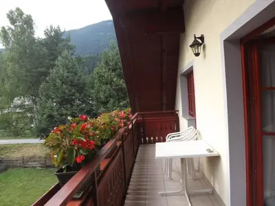a balcony with chairs and a table and flowers at Apartmaji Boštjan Pristavec in Kranjska Gora