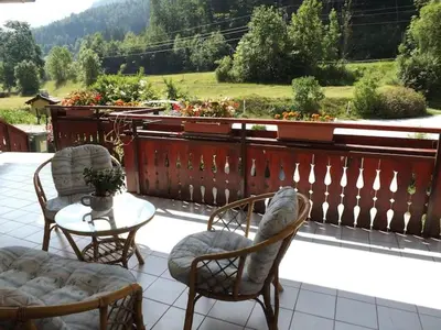 a patio with two chairs and a table and a fence at Apartmaji Boštjan Pristavec in Kranjska Gora