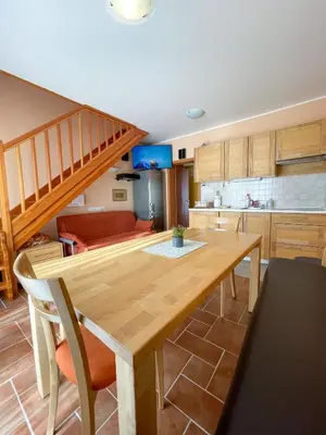 a kitchen and dining room with a wooden table at Apartma Idila in Zreče
