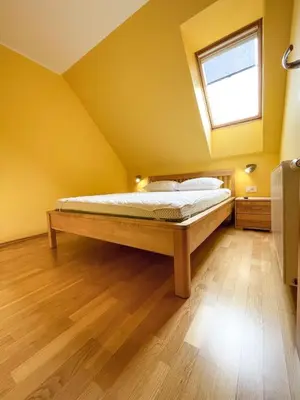 a bedroom with a bed in a yellow room at Apartma Idila in Zreče