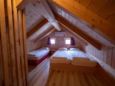 two beds in a room in a wooden attic at Chalet Sejalec in Lesce