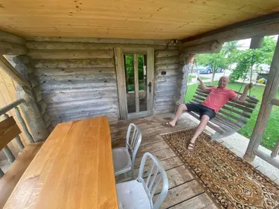 a man sitting on a bench in a cabin at Chalet Sejalec in Lesce