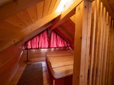 a small attic room with a bed and a window at Chalet Sejalec in Lesce
