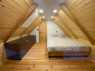 a bedroom with a bed and a large tv at Brunarica Chalet Rogla Sauna in Vitanje