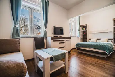 a small living room with a bed and a table at Studio CENTER in Zgornje Jezersko