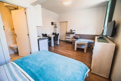 a room with a bed and a living room at Studio CENTER in Zgornje Jezersko