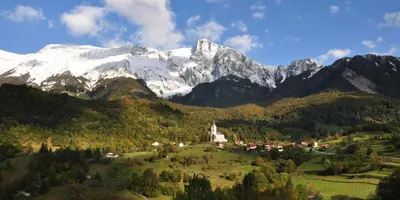 a mountain range with a town and a church on a hill at Apartma Mataj in Kobarid