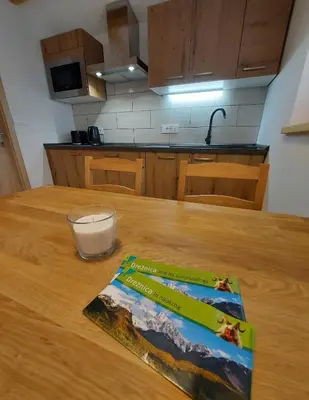 a book sitting on top of a wooden table in a kitchen at Apartma Mataj in Kobarid