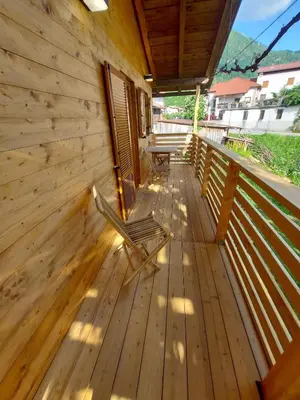 a wooden deck with two chairs on it at Apartma Mataj in Kobarid