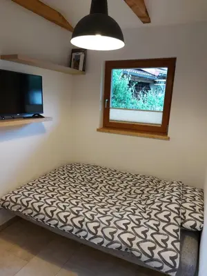 a room with a bed and a flat screen tv at Apartma Mataj in Kobarid