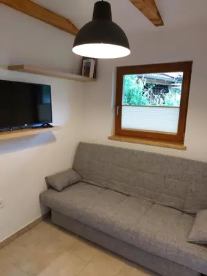a living room with a couch and a flat screen tv at Apartma Mataj in Kobarid