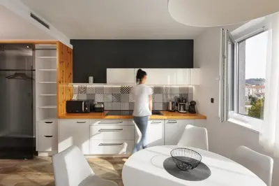 a woman standing in the kitchen of a house at CITYMAP HOTEL APARTMENTS Maribor-Free parking! in Maribor