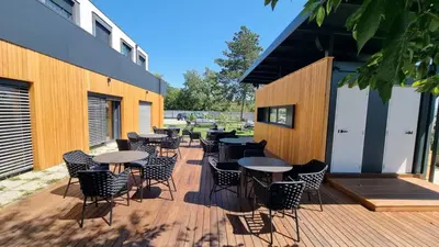 a deck with tables and chairs on a building at CITYMAP HOTEL APARTMENTS Maribor-Free parking! in Maribor