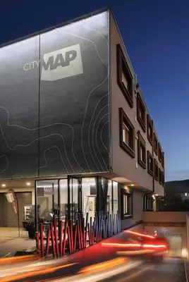 a building with a sign on the side of it at CITYMAP HOTEL APARTMENTS Maribor-Free parking! in Maribor