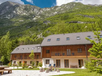 a large building with a mountain in the background at Residence Soča in Soča