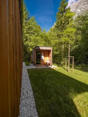 a house in the woods with a grass yard at Residence Soča in Soča