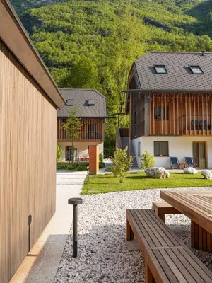 a courtyard with benches and a house at Residence Soča in Soča