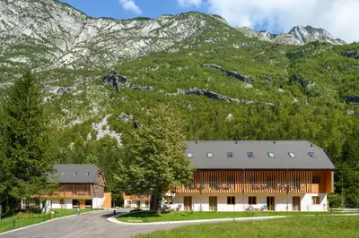 a building in front of a mountain at Residence Soča in Soča