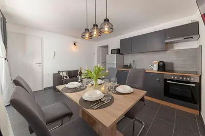 a kitchen and dining room with a table and chairs at Deluxe Apartments 55 in Kranjska Gora