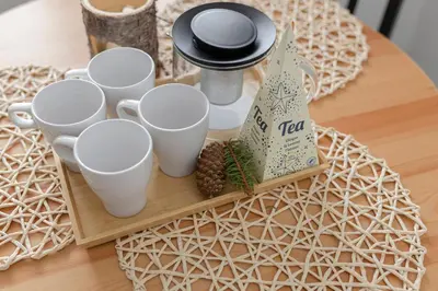 a tray with cups and pine cones on a table at Deluxe Apartments 55 in Kranjska Gora