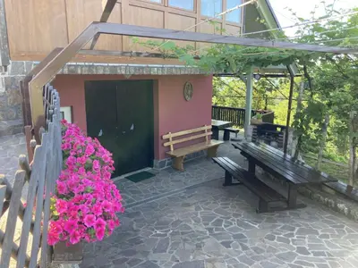 a patio with benches and flowers in front of a building at Vineyard Cottage Slanc in Metlika