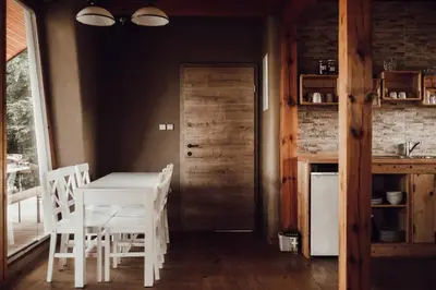 a kitchen and dining room with a white table and chairs at Ecological farm Makrobios Panonija in Gornji Petrovci