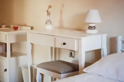 a white desk with a lamp and a chair next to a bed at Ecological farm Makrobios Panonija in Gornji Petrovci