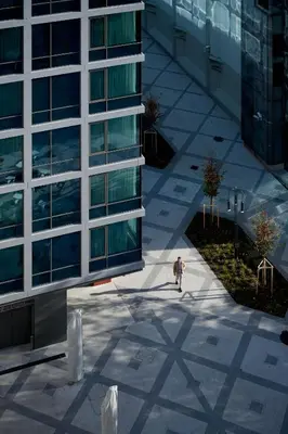 a man walking down a sidewalk in front of a building at NEU RESIDENCES smart stay in Ljubljana