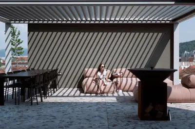 a woman sitting in a chair on a patio at NEU RESIDENCES smart stay in Ljubljana