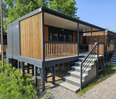a tiny house with wooden panels and stairs at BIG BERRY Kolpa - MerryBerry mobile house in Metlika