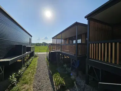 a couple of buildings sitting next to each other at BIG BERRY Kolpa - MerryBerry mobile house in Metlika