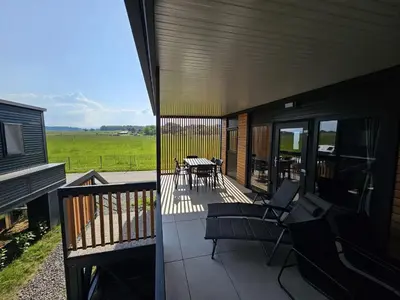 a screened porch with chairs and a table on a house at BIG BERRY Kolpa - MerryBerry mobile house in Metlika