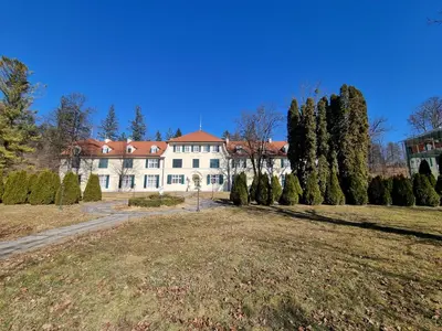 a large white house with trees in front of it at Apartma Vrtnica, Vila Golf in Rogaška Slatina