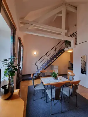 a dining room with a table and chairs and a staircase at Apartma Vrtnica, Vila Golf in Rogaška Slatina
