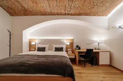 a bedroom with a large bed and a desk at Operna klet Ljubljana in Ljubljana