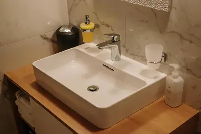 a white sink sitting on a wooden counter in a bathroom at Operna klet Ljubljana in Ljubljana