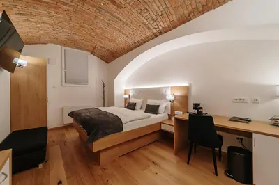 a bedroom with a bed and a desk in a room at Operna klet Ljubljana in Ljubljana