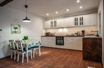 a kitchen with white cabinets and a table and chairs at Entire house in the center of Ljubljana - FREE PARKING - Dragon Garden Pavilion Ljubljana in Ljubljana